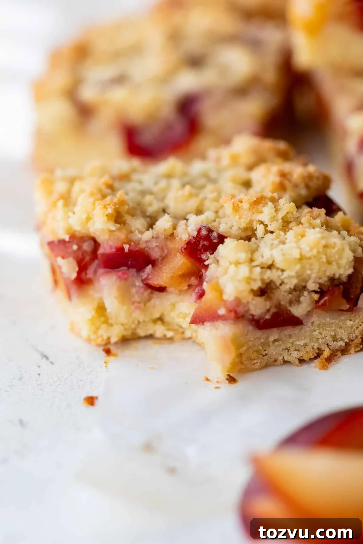 close up on a plum bar with a bite taken out of it.