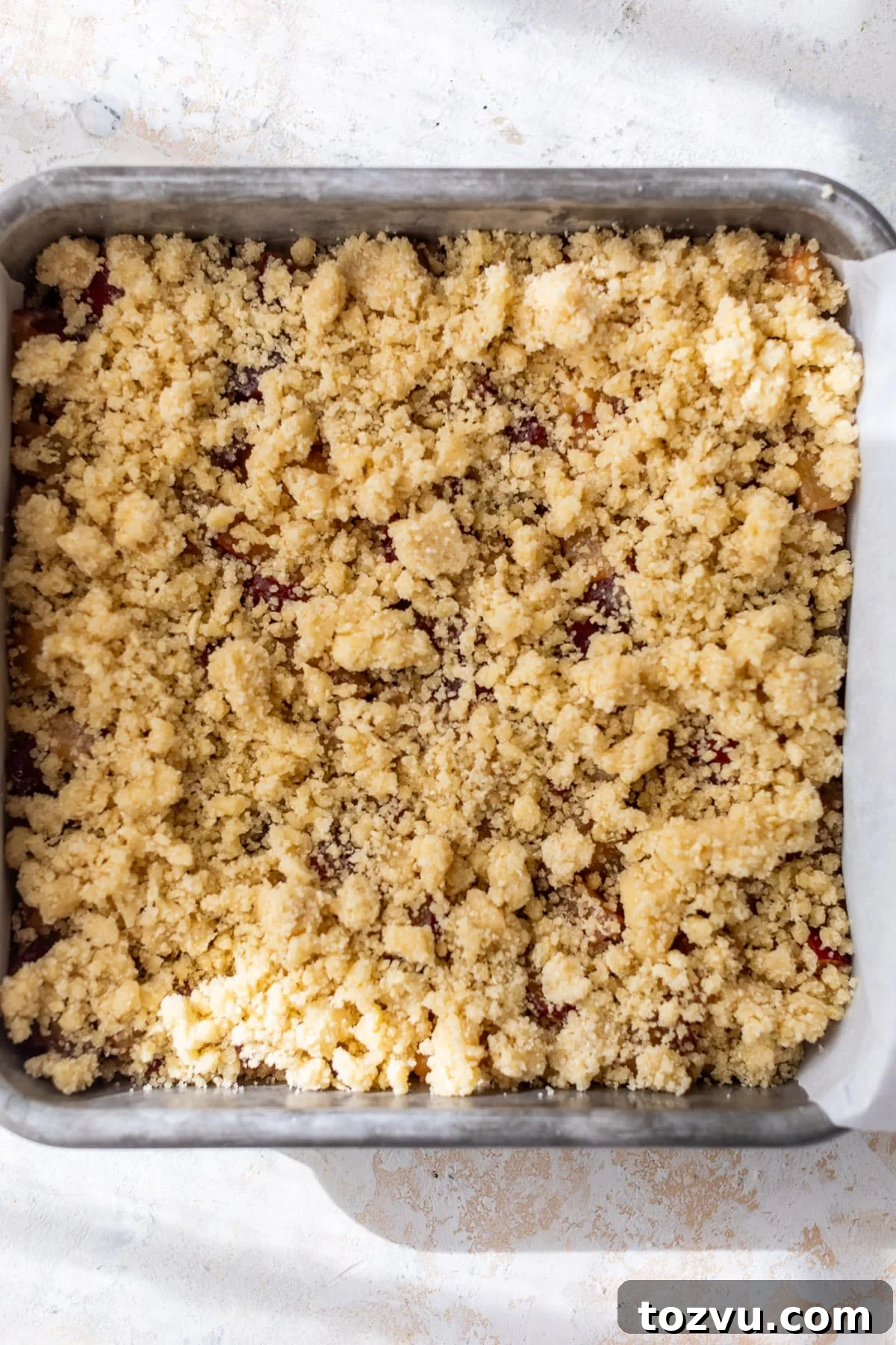 assembled and unbaked plum bars in a baking dish.