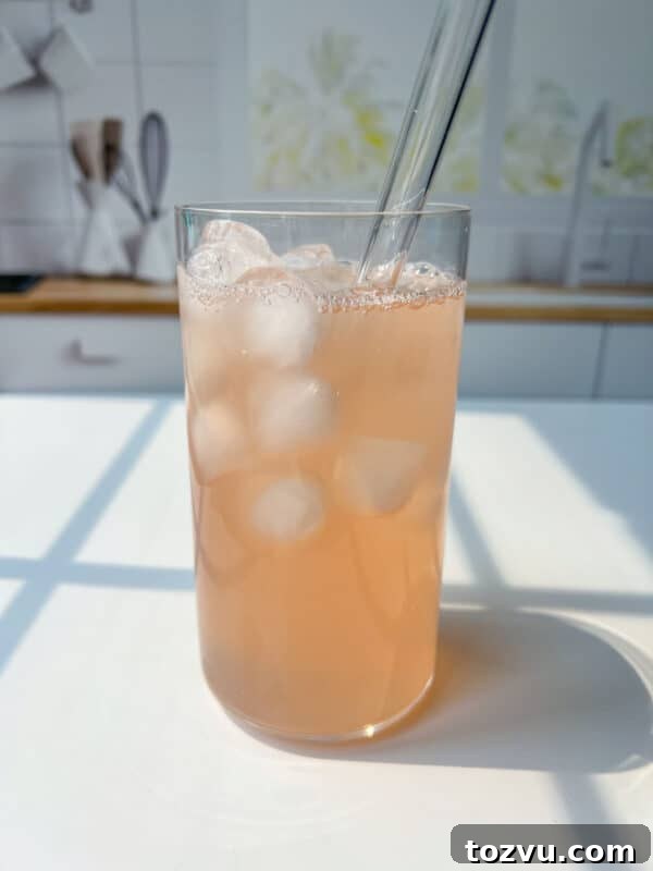 Classic Mixed Fruit Compote Recipe for Dessert & Breakfast 3 A glass of light pink iced drink inspired by a Fruit Compote Recipe