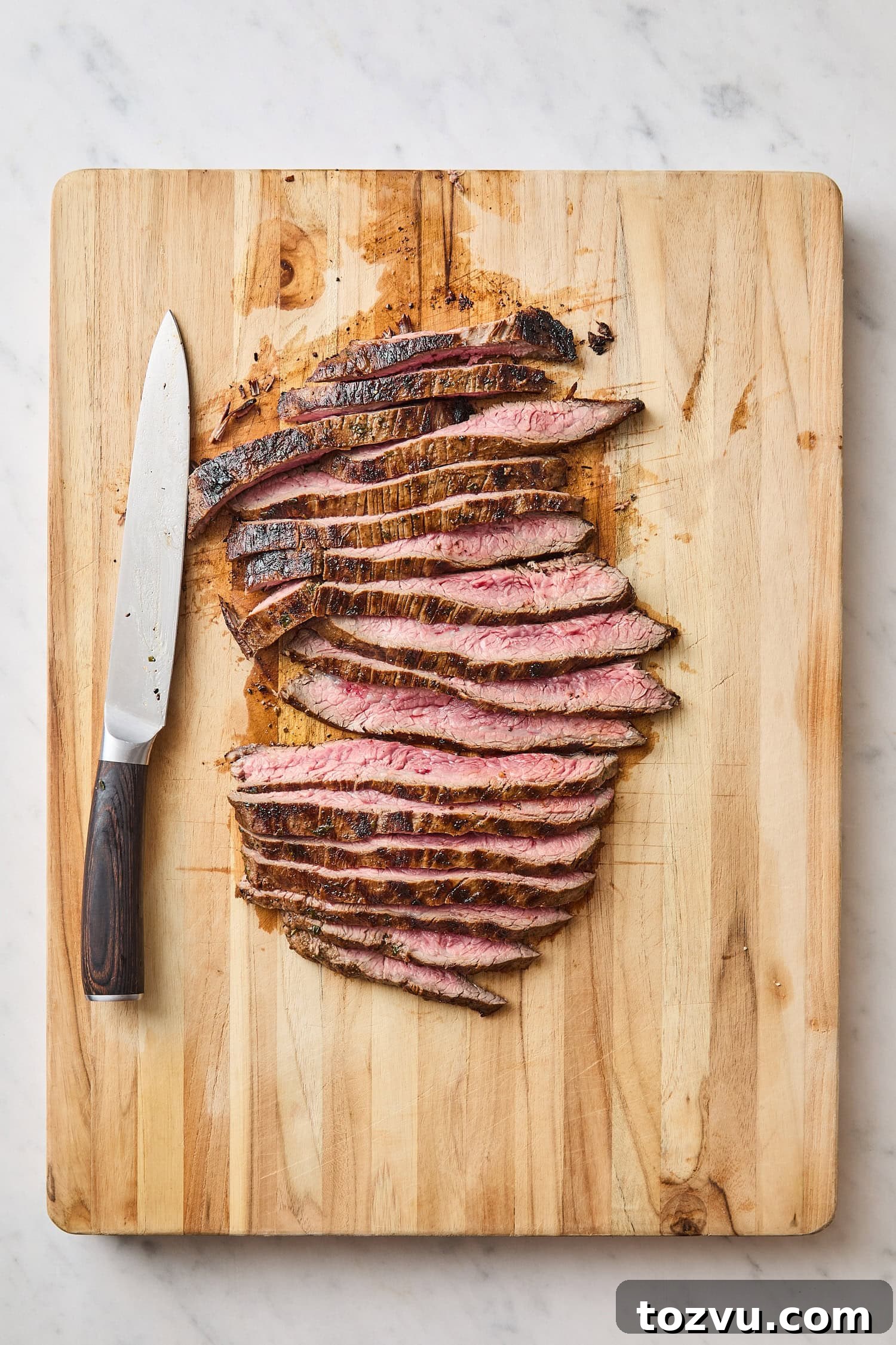 Grilled Steak with Roasted Beet and Goat Cheese Salad 11 Wooden cutting board with slices of freshly grilled steak.