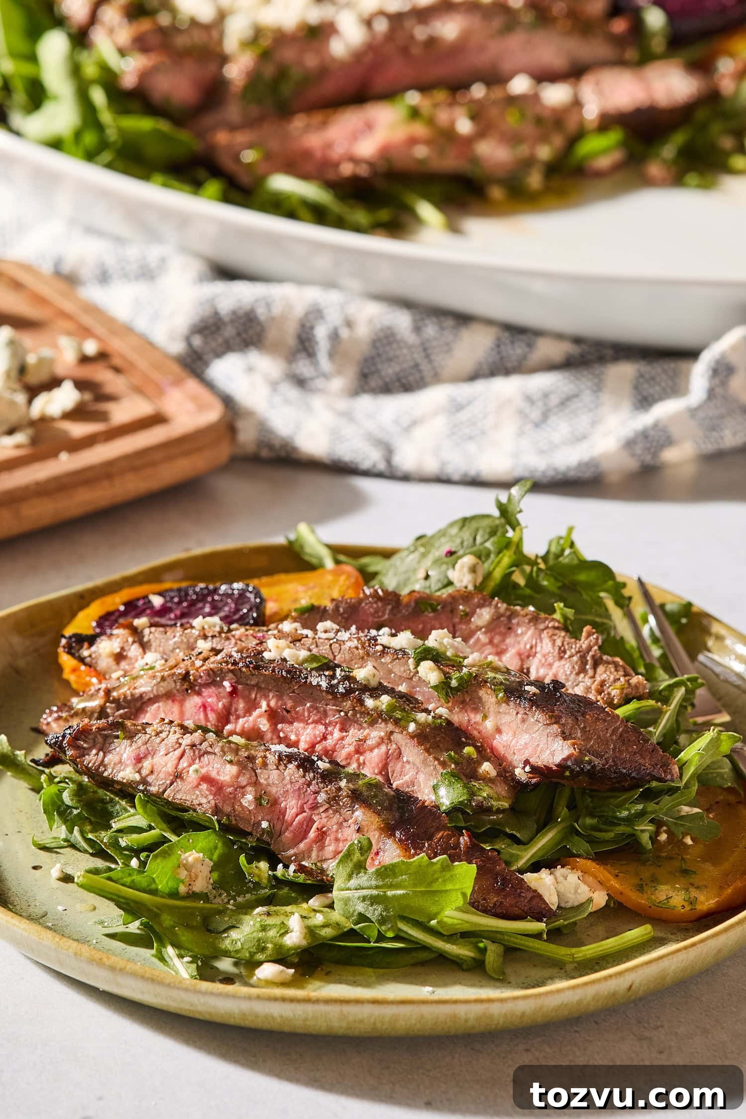 Grilled Steak with Roasted Beet and Goat Cheese Salad 13 Plate with serving of steak and beet salad with crumbled blue cheese on top.