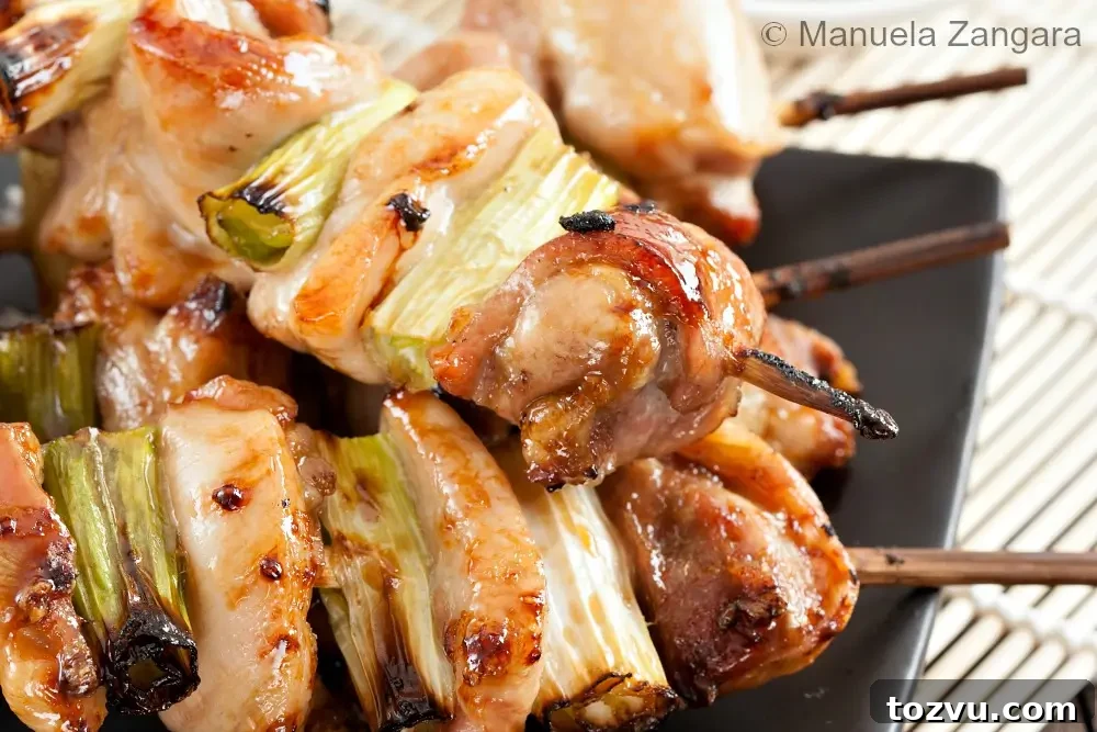 Yakitori: Authentic Japanese Grilled Chicken Skewers Recipe 3 Close-up of glazed chicken and spring onion skewers with lightly charred edges.