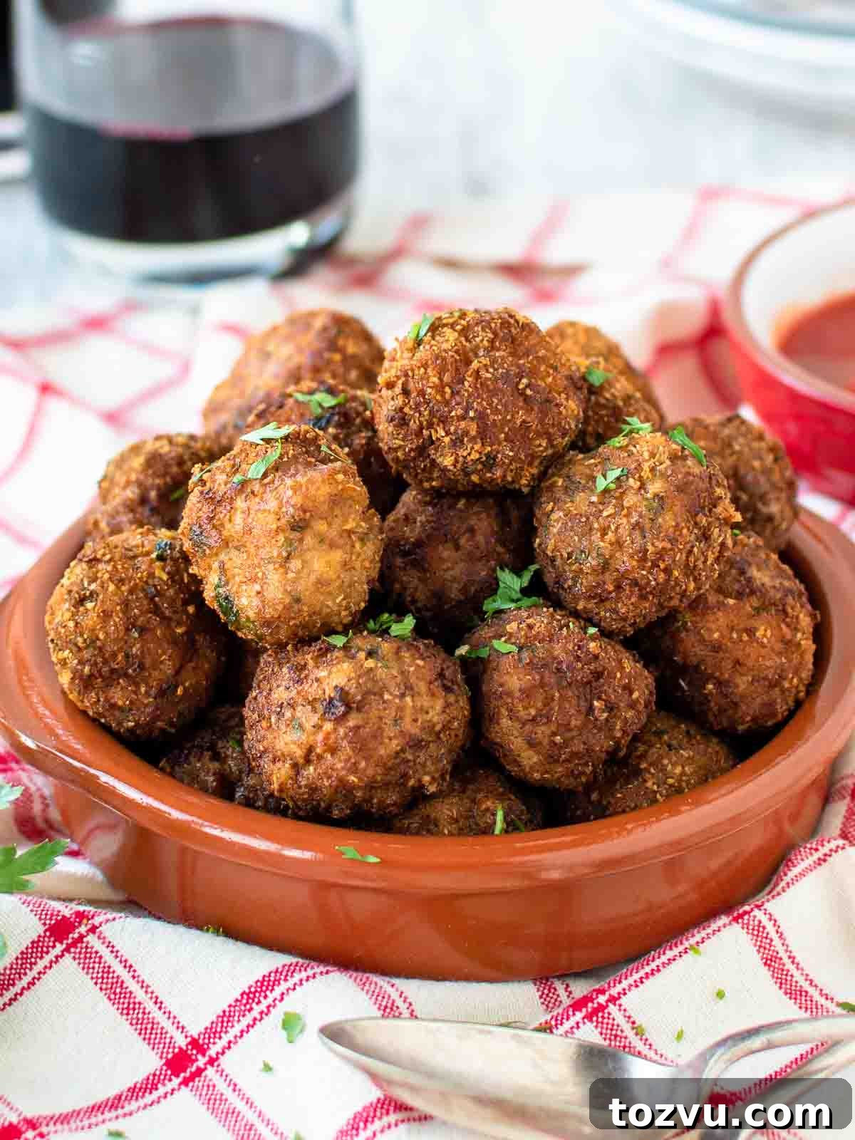 Crispy Fried Meatballs with Garlic Dipping Sauce 2 Fried Meatballs piled into a shallow terracotta bowl.