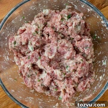 Crispy Fried Meatballs with Garlic Dipping Sauce 5 Raw meatballs mixture in a glass bowl viewed from above.