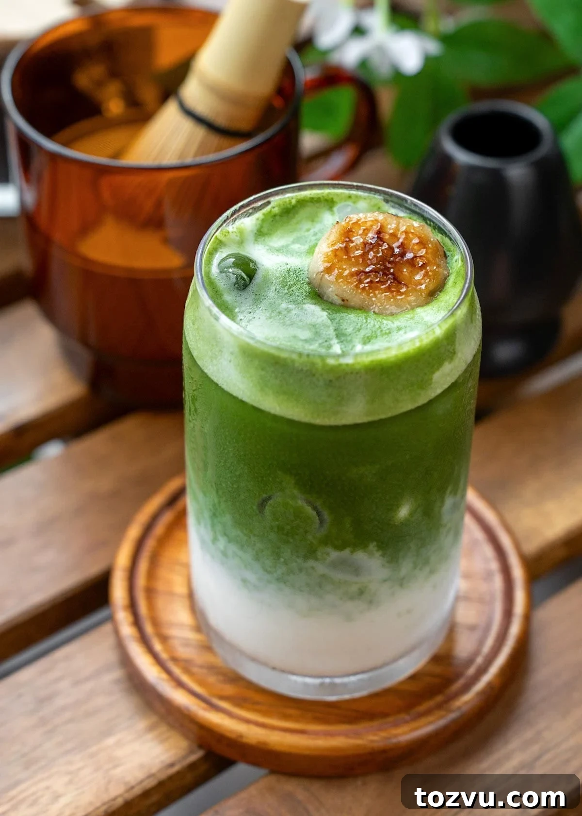 Creamy Banana Matcha Latte Recipe 2 A layered banana matcha latte with a caramelized banana garnish