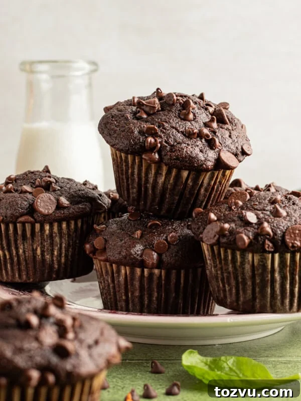 Chocolate veggie muffins stacked on a plate.