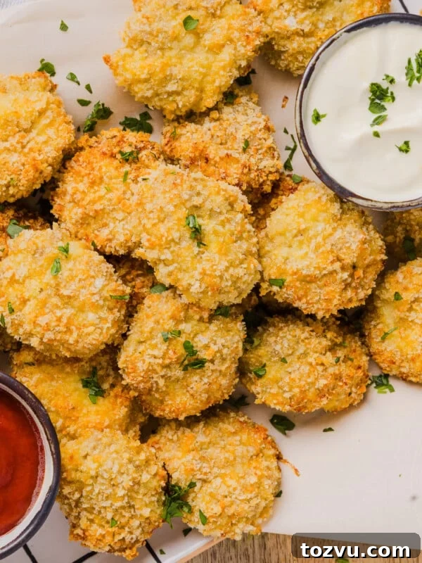 Cauliflower chicken nuggets with two dipping sauces on parchment paper.