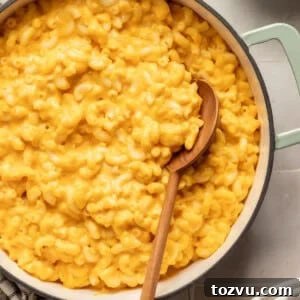Hidden veggie Mac and cheese in a pot with a wooden spoon.