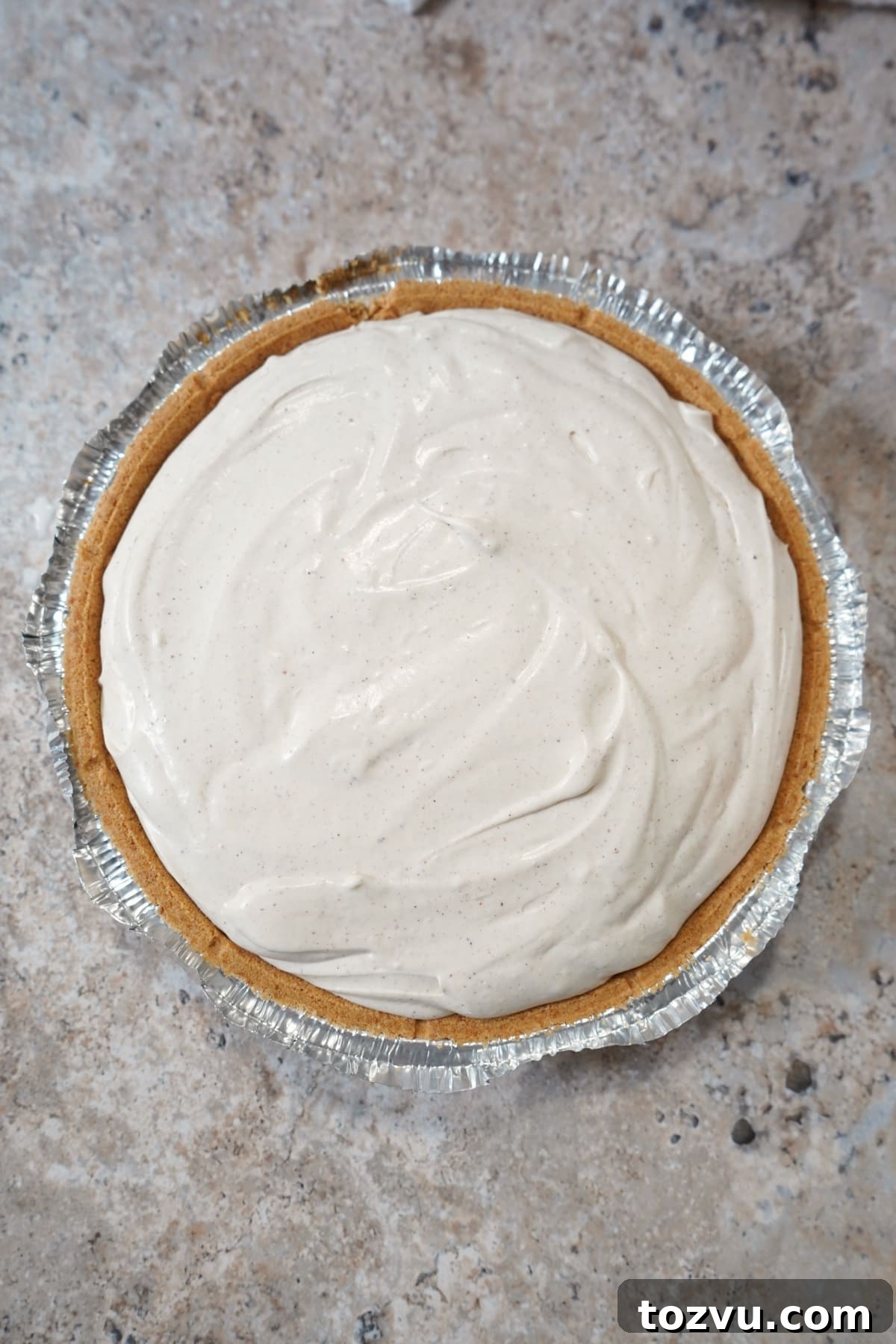No-Bake Eggnog Cheesecake with a Boozy Twist 5 eggnog cheesecake filling in crust.