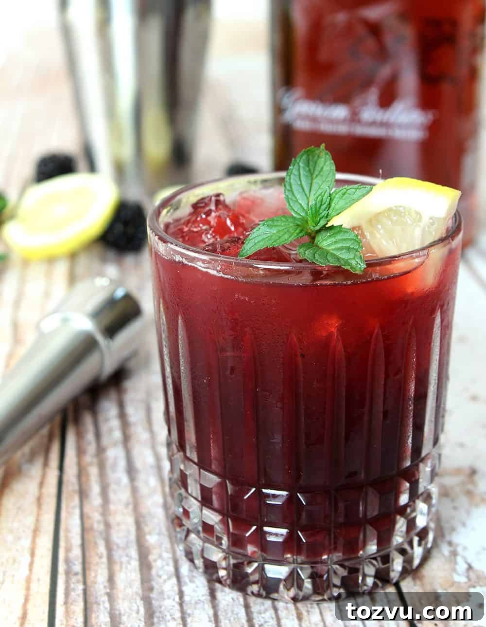 Blackberry Smash Cocktail made with blackberries, whiskey, and mint in a cut crystal low ball glass.