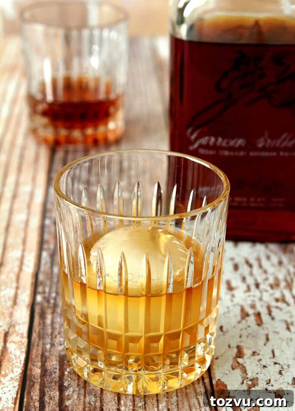 Low-ball glass of Garrison Brothers Whiskey with round ice ball.