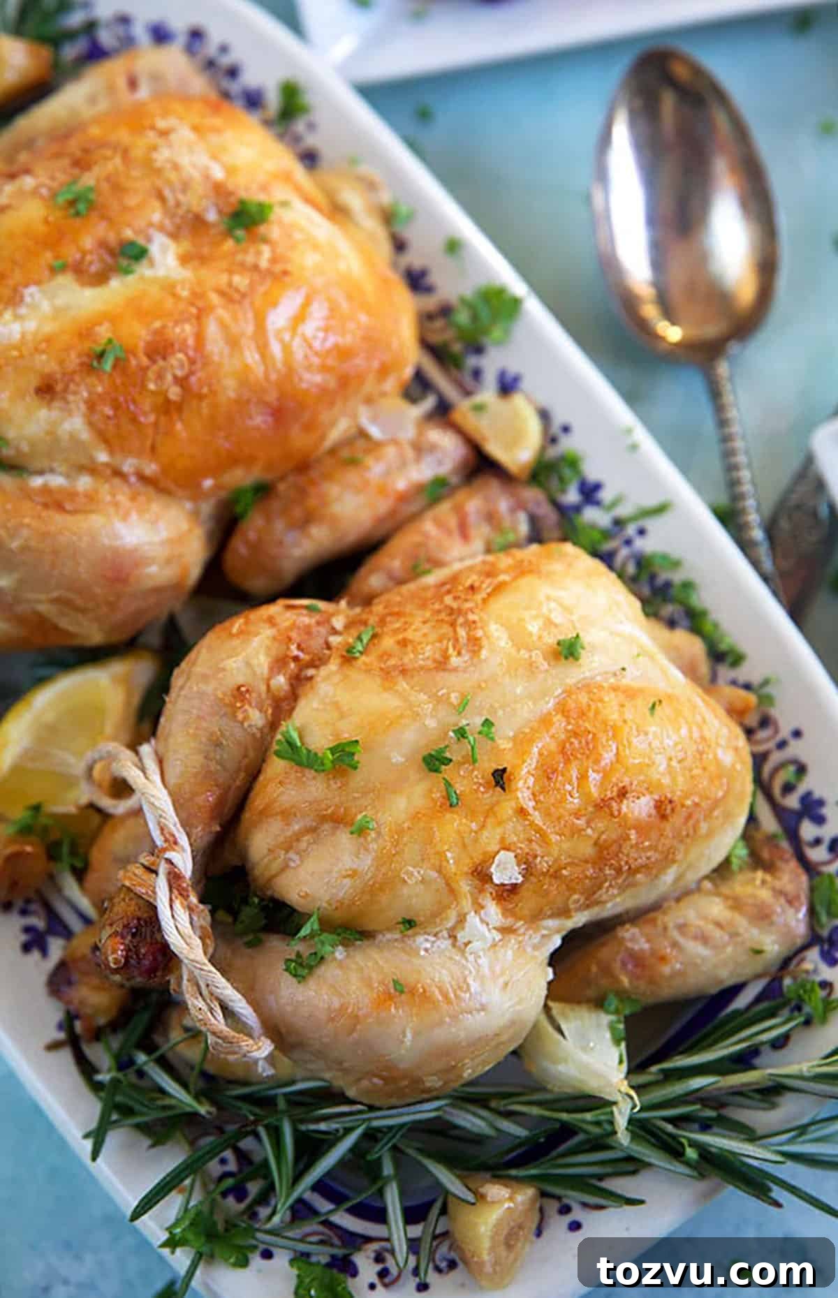 Herb-Roasted Cornish Game Hen with Crispy Skin 3 Overhead shot of two cornish hens on a platter.