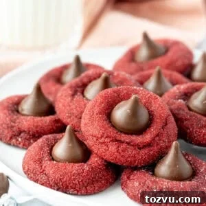 Plate of red velvet blossom cookies, each cookie topped with a Hershey's Kiss