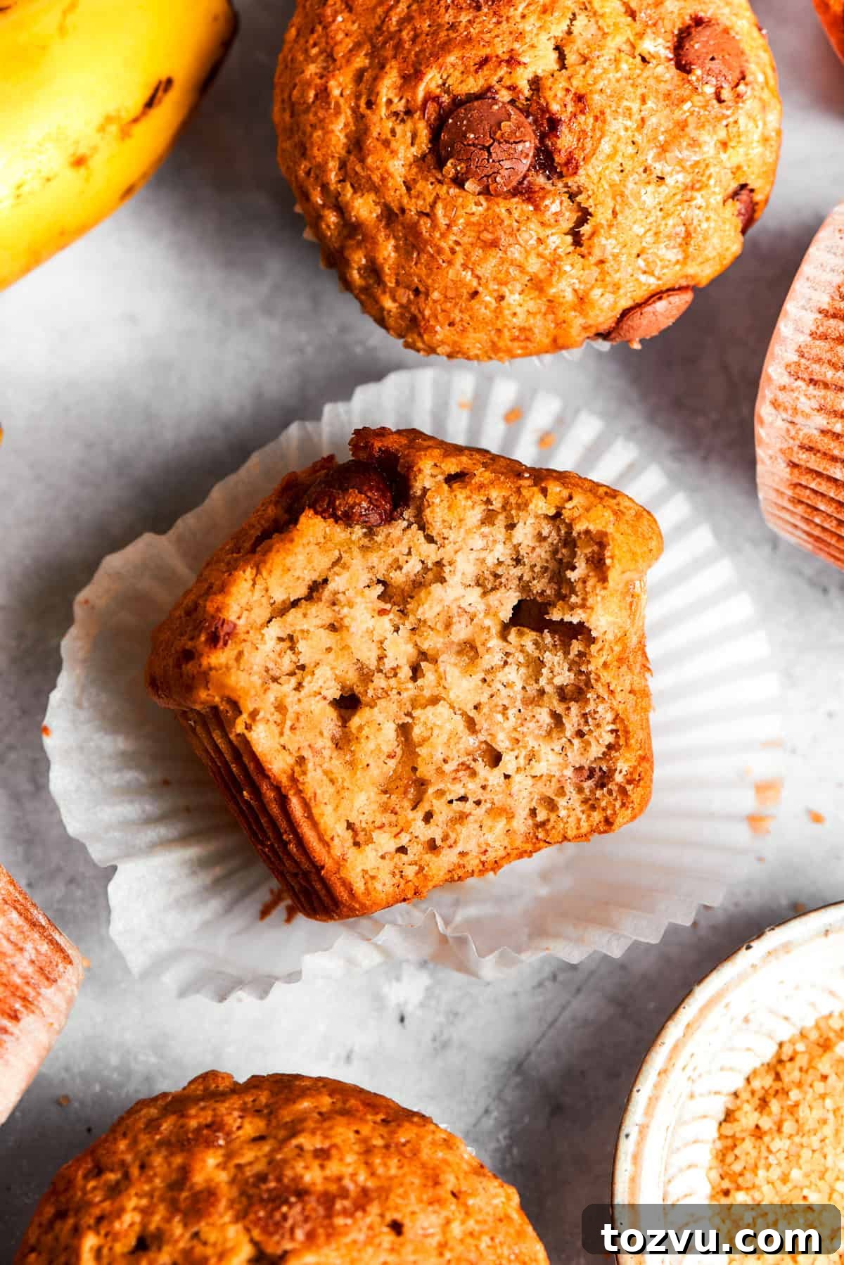 Halved muffin set flat on a cupcake liner, with the soft center exposed.