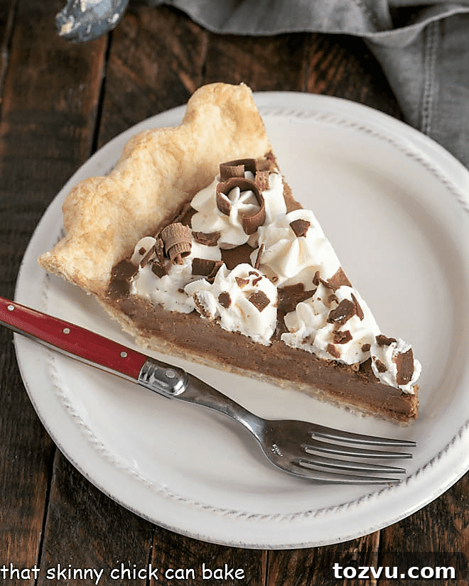 Chocolate Pie Recipe with Frangelico - the most luscious chocolate pie you'll ever encounter!! Overhead view of a slice of french silk pie with a red handle fork.