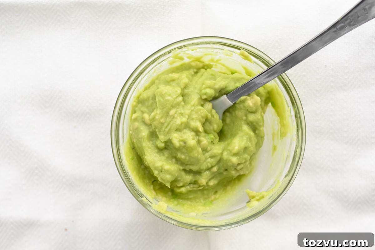 How to Make Avocado Puree for Baby Food 2 smooth avocado puree in a glass dish with a baby spoon