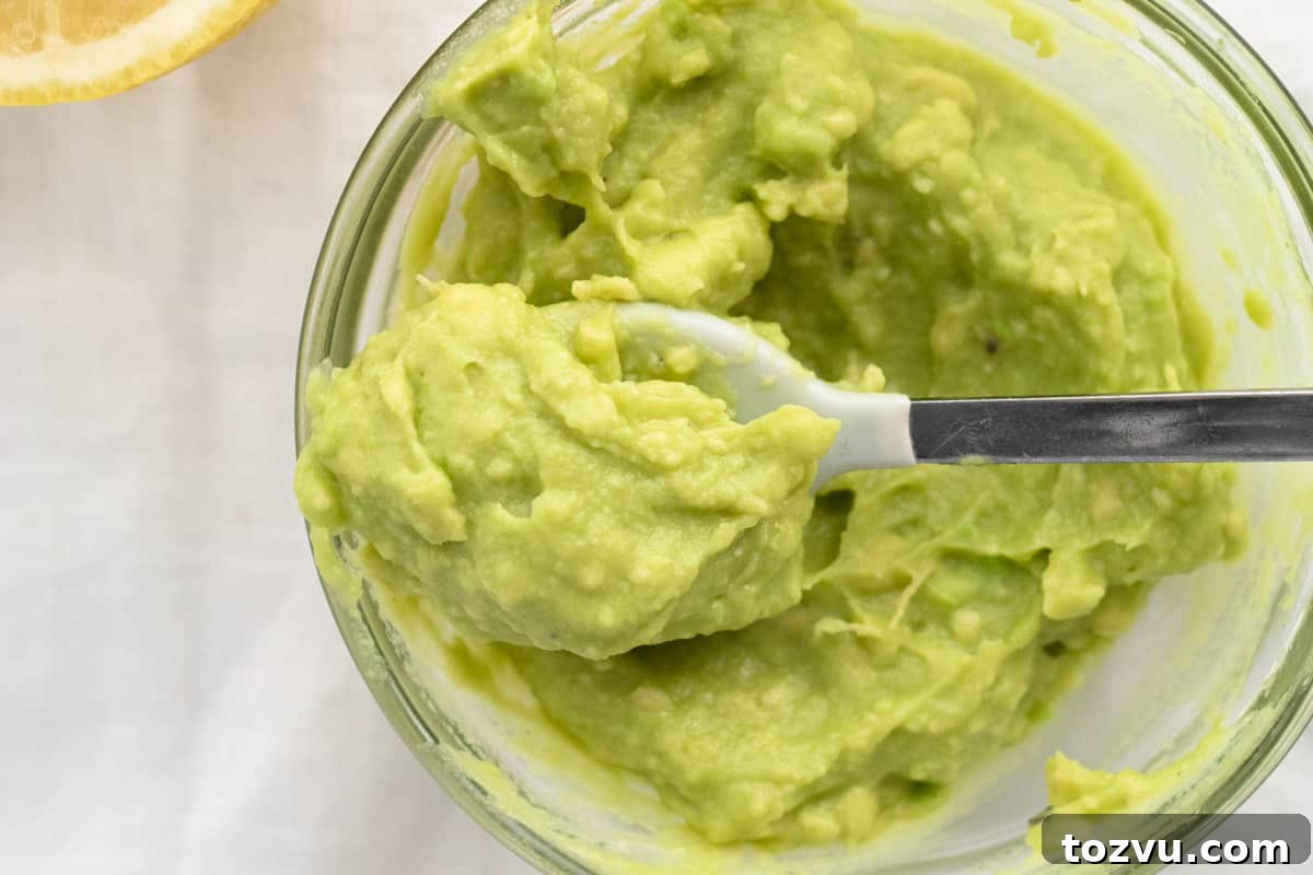 How to Make Avocado Puree for Baby Food 7 close up of smooth avocado on a baby spoon