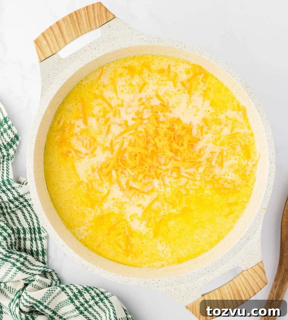 adding cheese to the potato soup