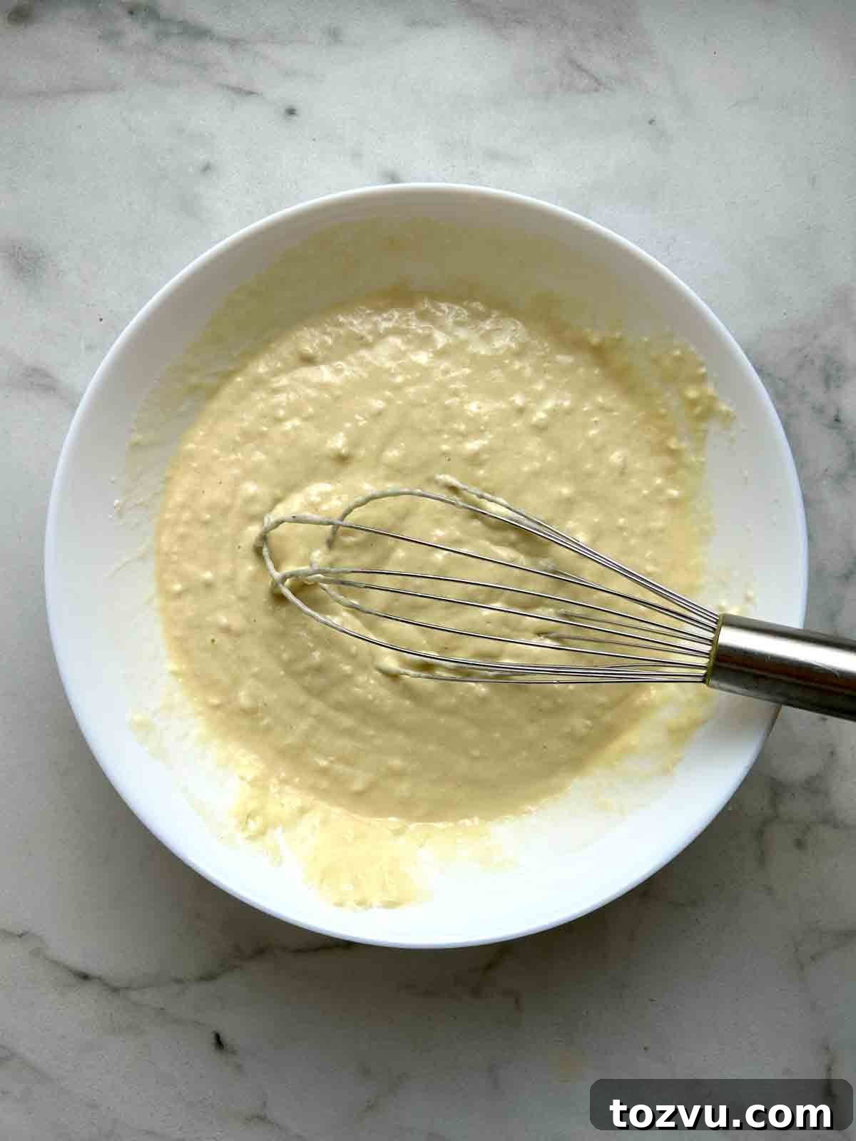 Fluffy Dairy-Free Pancakes Without Milk 6 batter whisked in white bowl.