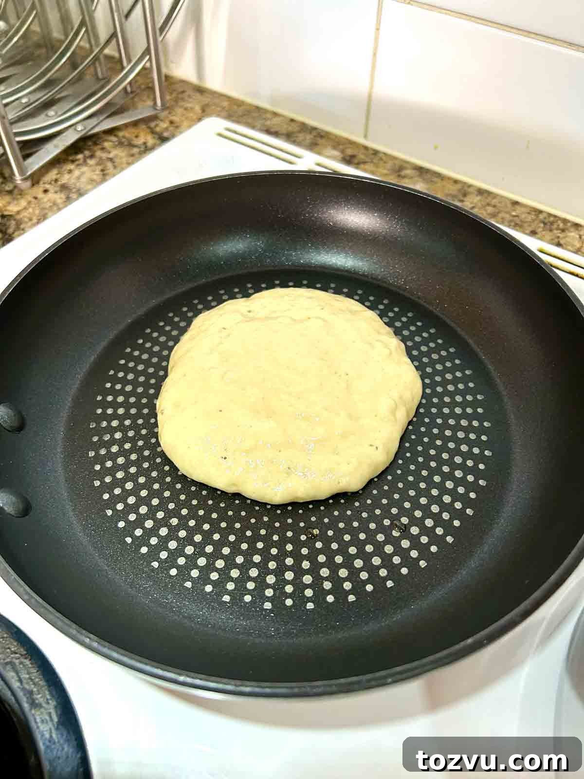 Fluffy Dairy-Free Pancakes Without Milk 7 pancake batter scooped into skillet.