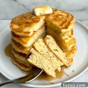 stack of pancakes with section cut through all of them to show the fluffy inside.