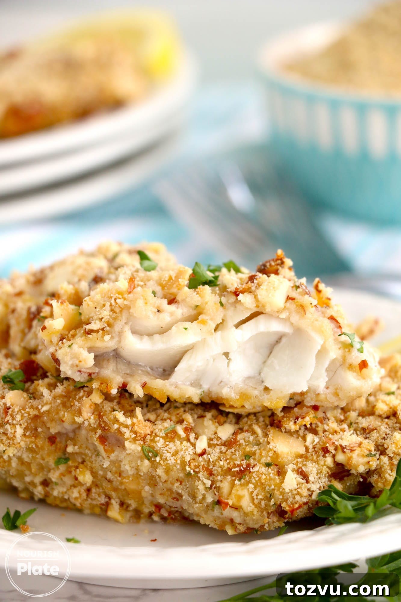 Crispy Almond-Crusted Fish with Lemon Butter 2 Stacked 2 pieces of almond crusted walleye fish fillets, showing the inside texture