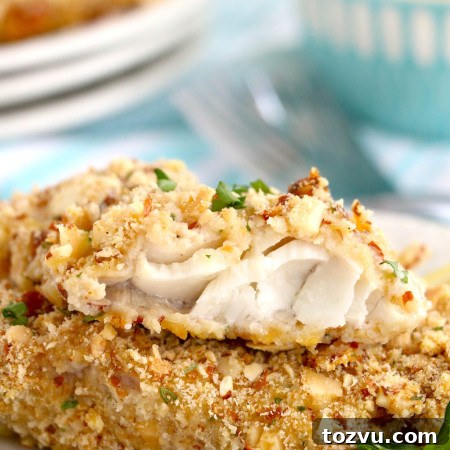 Stacked 2 pieces of almond crusted walleye fish fillets, showing the inside texture