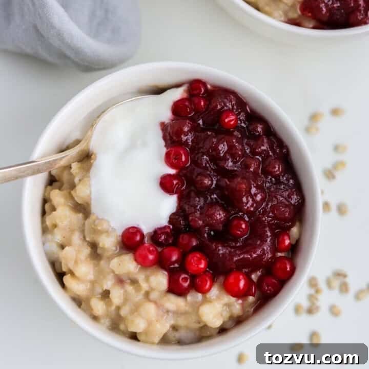 Close up of a bowl of Creamy Barley Breakfast Porridge with a spoon.