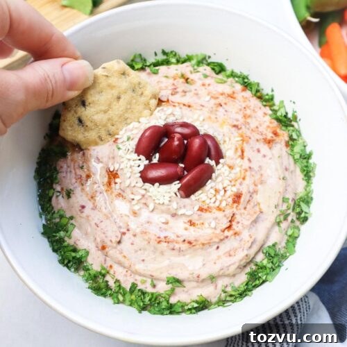 bowl with kidney bean hummus topped with sesame seeds, cilantro, and kidney beans.