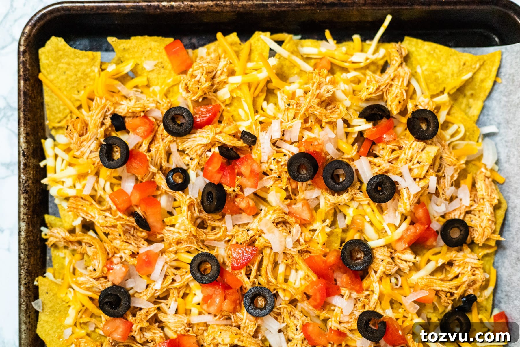 Loaded Buffalo Chicken Nachos with Creamy Ranch Drizzle 6 Nachos assembled on a baking sheet