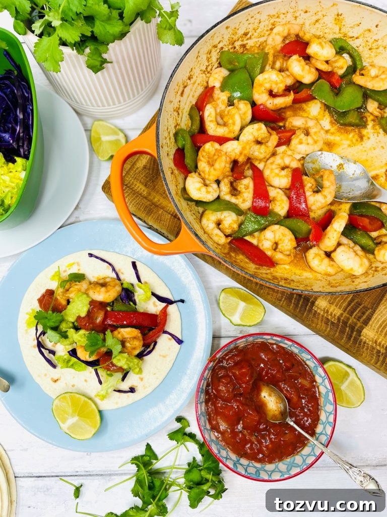 20-Minute Shrimp Fajitas with Peppers and Lime 2 Mexican prawn fajitas being served from a skillet pan. Fajita is loaded with lettuce, shredded red cabbage, prawns, guacamole and tomato salsa.