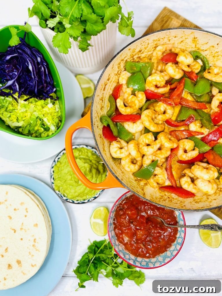 20-Minute Shrimp Fajitas with Peppers and Lime 13 Mexican prawn fajitas being served from a skillet pan. Fajita is loaded with lettuce, shredded red cabbage, prawns, guacamole and tomato salsa.