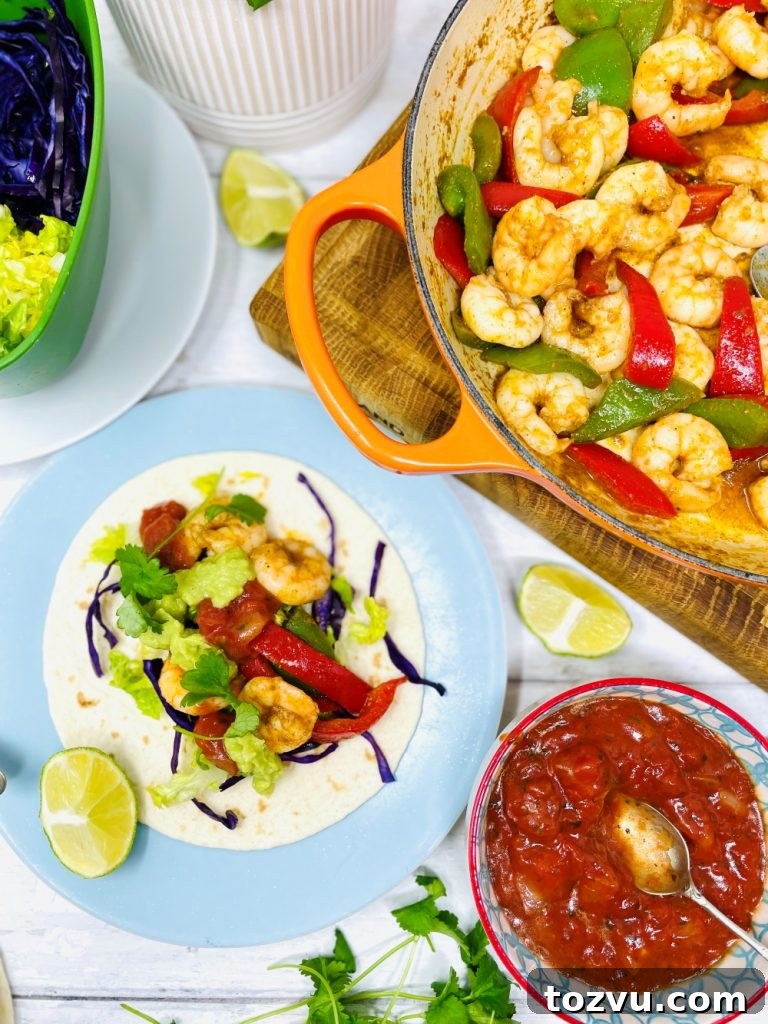 20-Minute Shrimp Fajitas with Peppers and Lime 9 Mexican prawn fajitas being served from a skillet pan. Fajita is loaded with lettuce, shredded red cabbage, prawns, guacamole and tomato salsa.