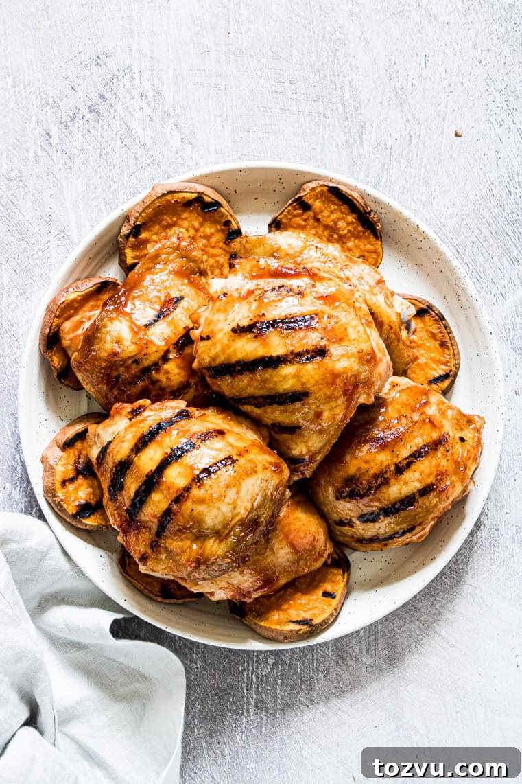 How to Grill Chicken Thighs for Juicy, Crispy Results 5 grilled chicken thighs on a white plate