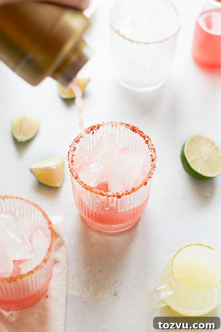 woman pouring fresh watermelon cocktails into glasses