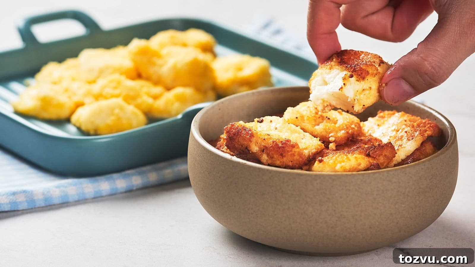 17 Thanksgiving Recipes Ready in Minutes 2 A hand picks up a piece of fried cheese curd from a bowl.