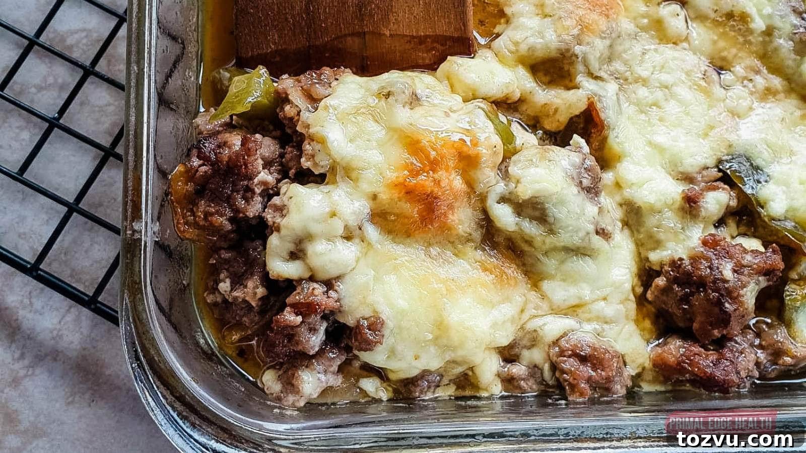 17 Thanksgiving Recipes Ready in Minutes 8 Image shows a wooden spatula cutting philly cheesesteak casserole from baking dish.