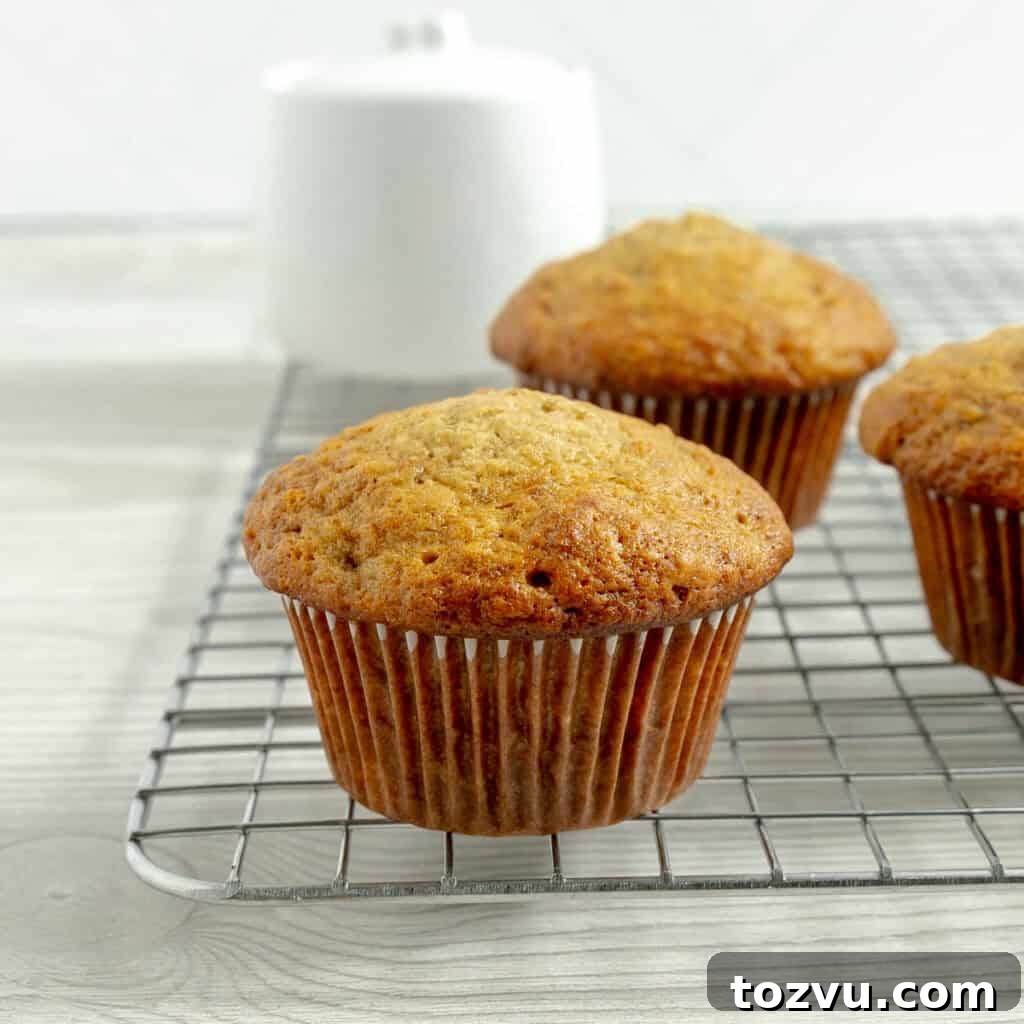 Image of a banana muffin on a cooling rack with other banana muffins.