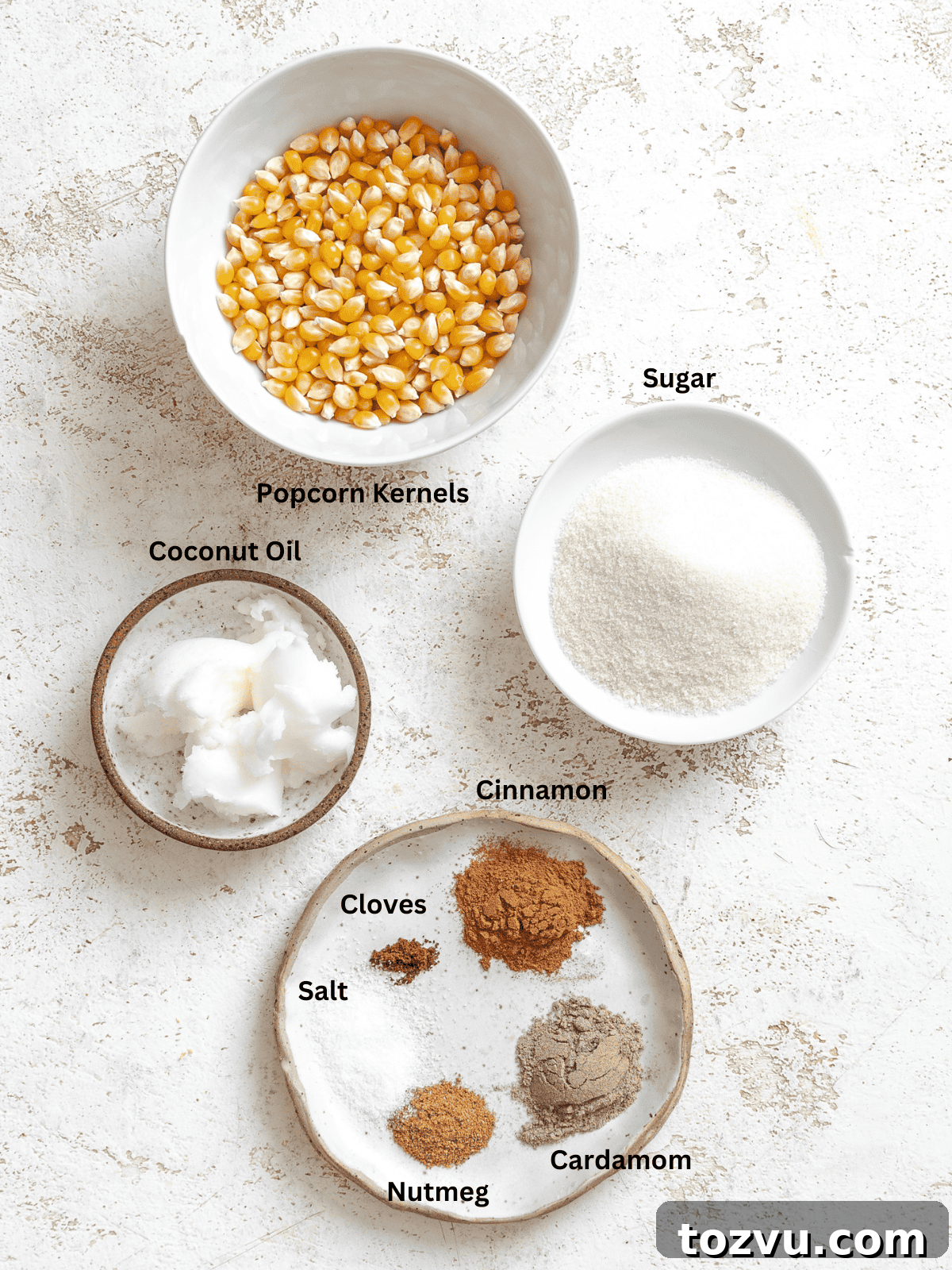 Ingredients for Chai Popcorn measured out on a white surface.