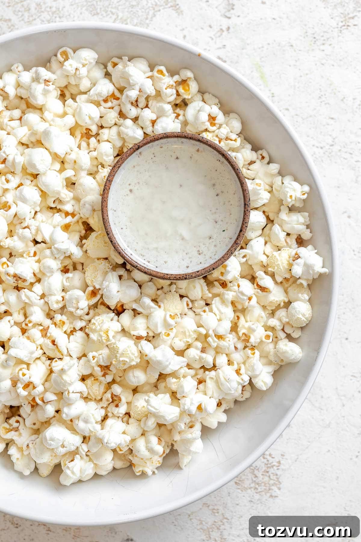 Process shot showing a small bowl inside bowl of popcorn.