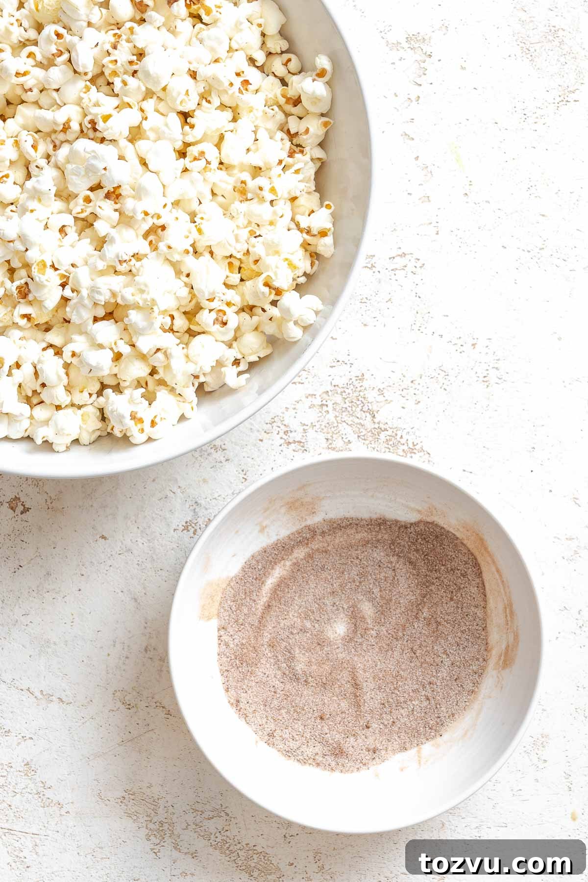 Process shot showing a bowl of popcorn alongside seasoning mix.